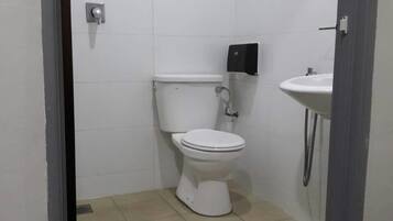 Un baño pequeño y cerrado con inodoro, bidé y lavabo.