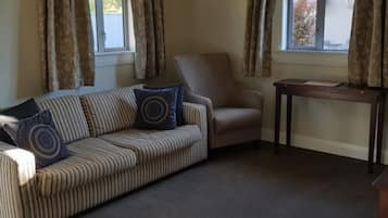 A living room with a striped sofa, a chair, and a small table.