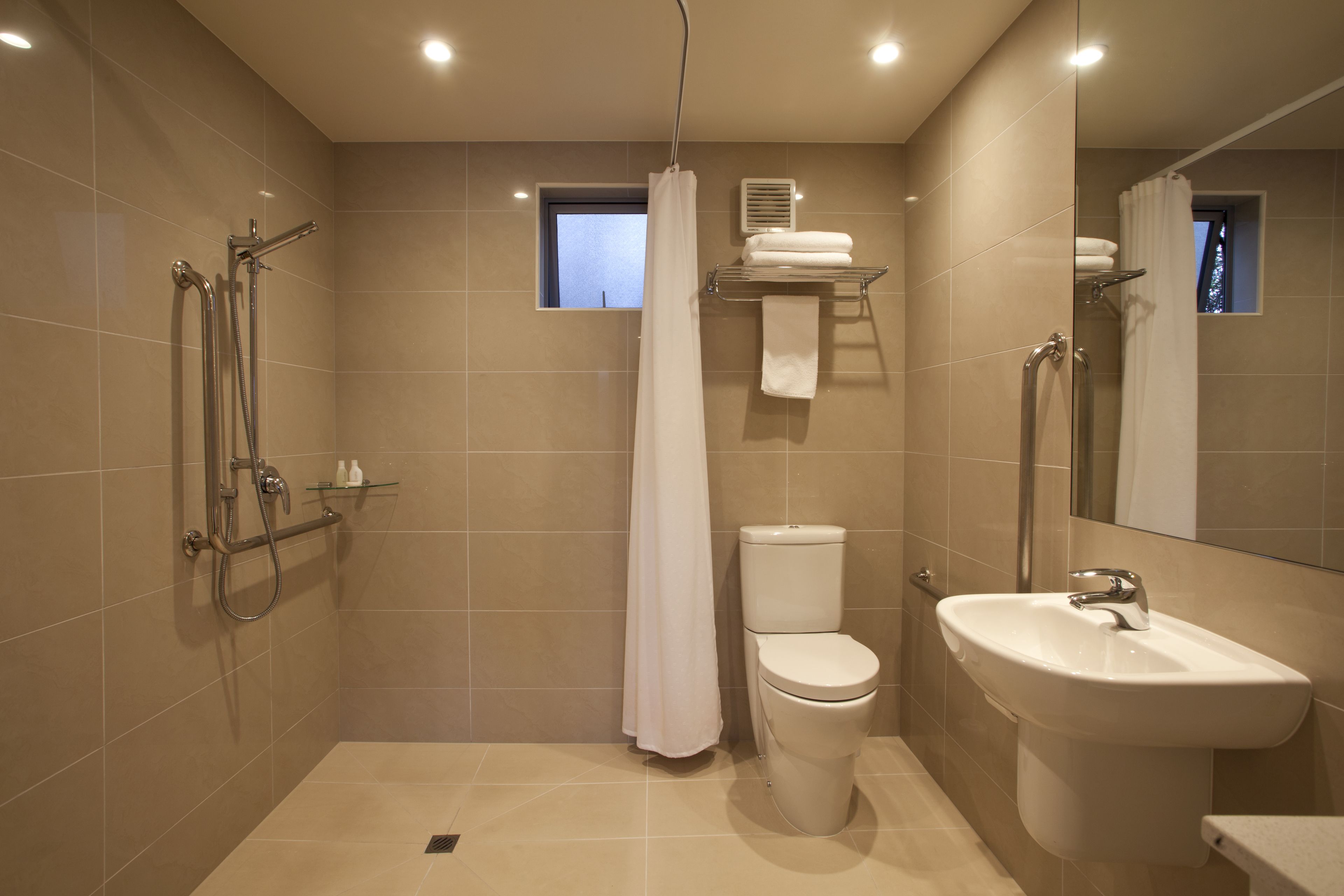 Un baño moderno con ducha, inodoro y lavamanos.