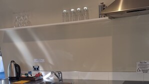 Una cocina moderna con electrodomésticos de acero inoxidable, lavavajillas integrado y un lavamanos grande.