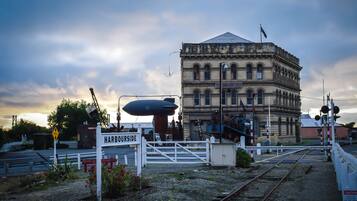 A historic building with a sign reading "Harbourside" and a railway crossing.