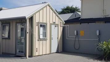 Um pequeno edifício térreo com fachada bege, uma porta e uma janela.