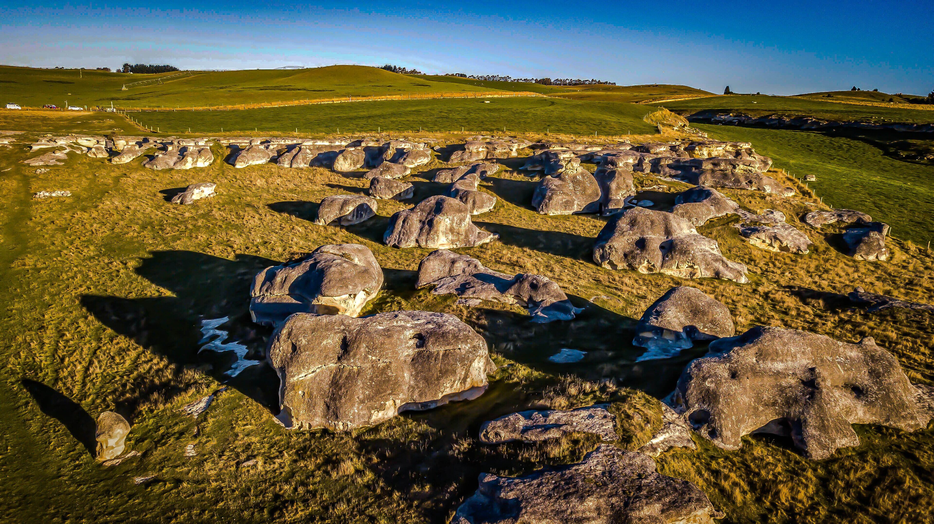 Un paisaje con grandes rocas y campos cubiertos de hierba.
