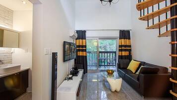 Habitación doble, vista al patio, mezzanine | Área de sala de estar | Televisión de pantalla plana de 42 pulgadas con canales por cable