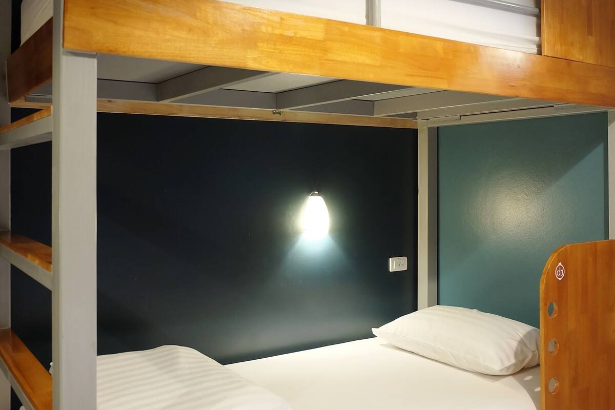 A bunk bed with a wooden frame and white bedding.