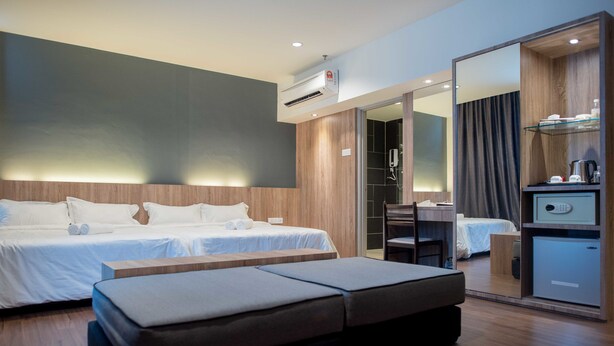 A modern hotel room with two beds, a wooden headboard, a large mirror, a desk, and a minibar. - Mornington Hotel Soon Choon (Ipoh)