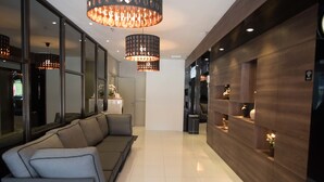 A modern hotel lobby with a sofa, pendant lights, and a wooden reception desk. - Mornington Hotel Soon Choon (Ipoh)