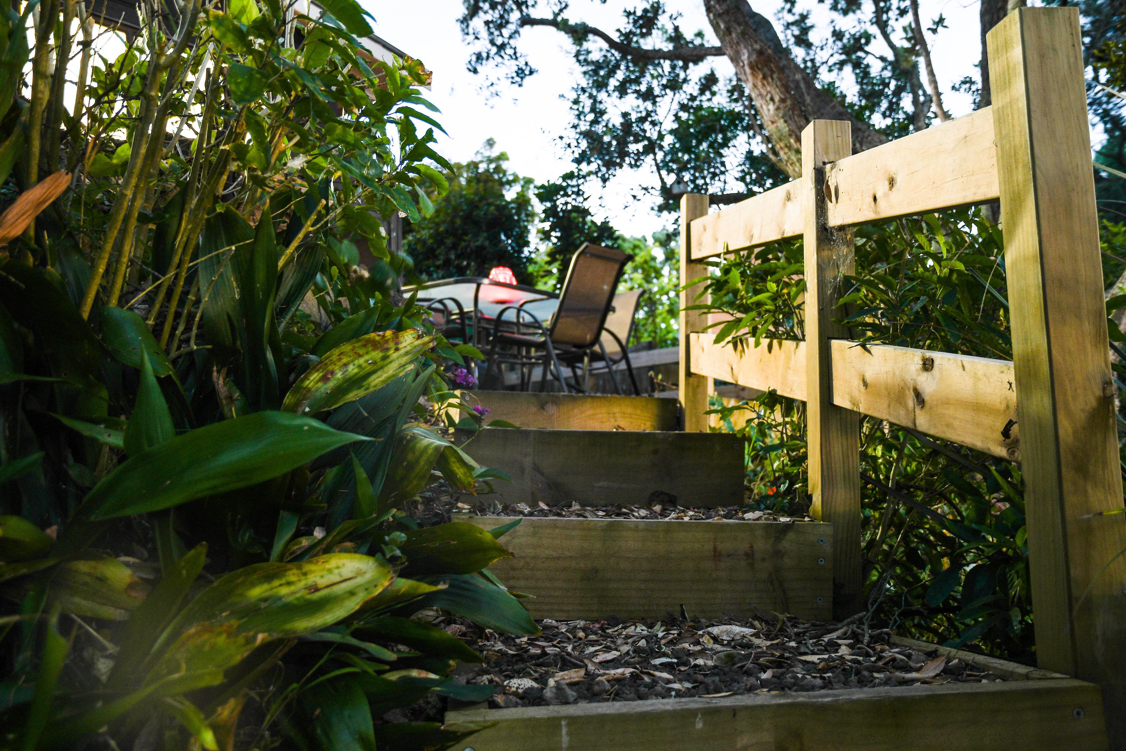 A wooden staircase leading to a patio area with a table and chairs.