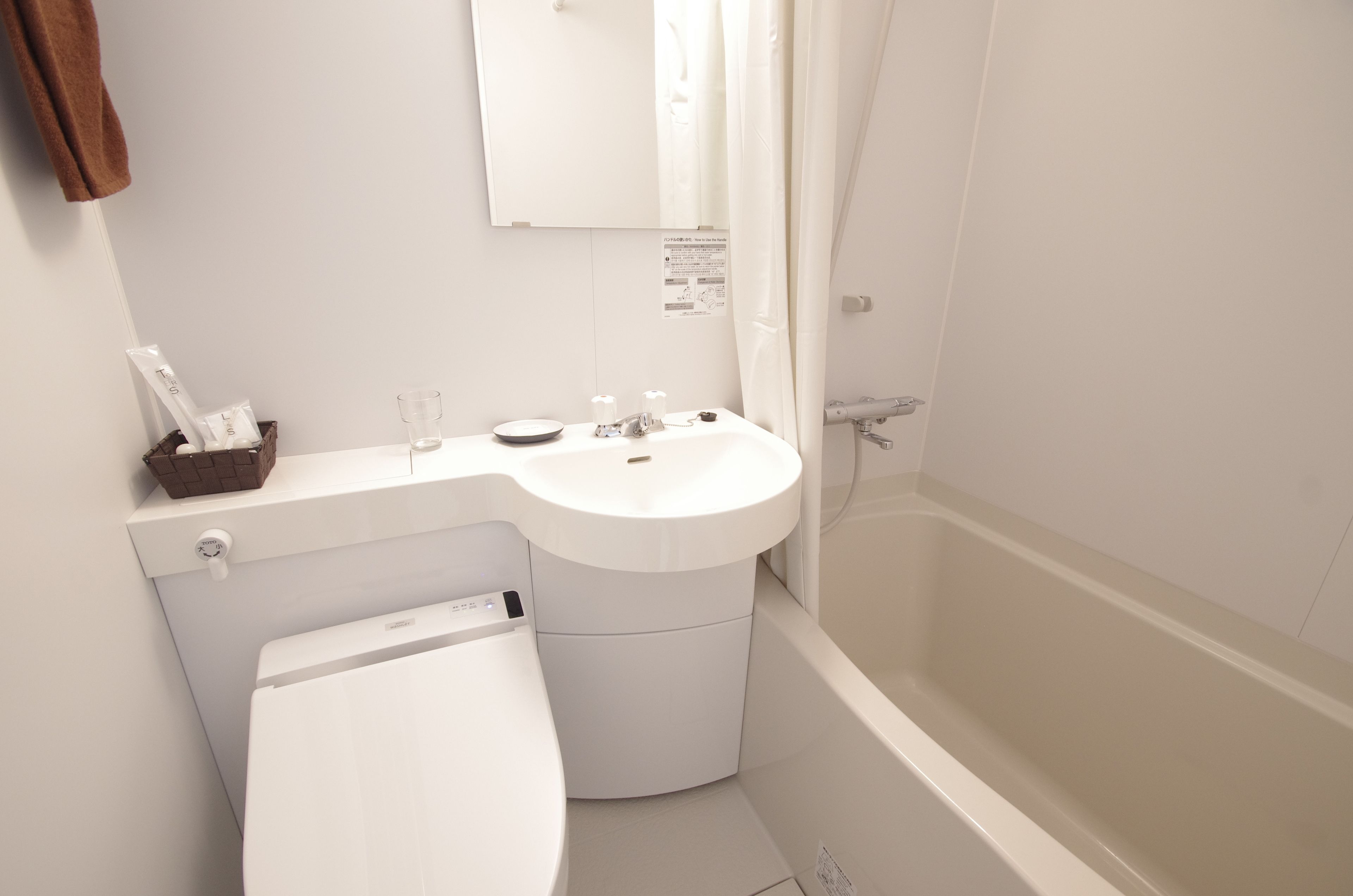 A modern bathroom with a white sink, toilet, and bathtub.