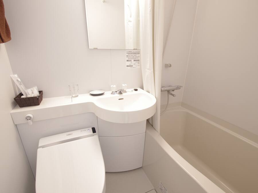 A modern bathroom with a white sink, toilet, and bathtub.
