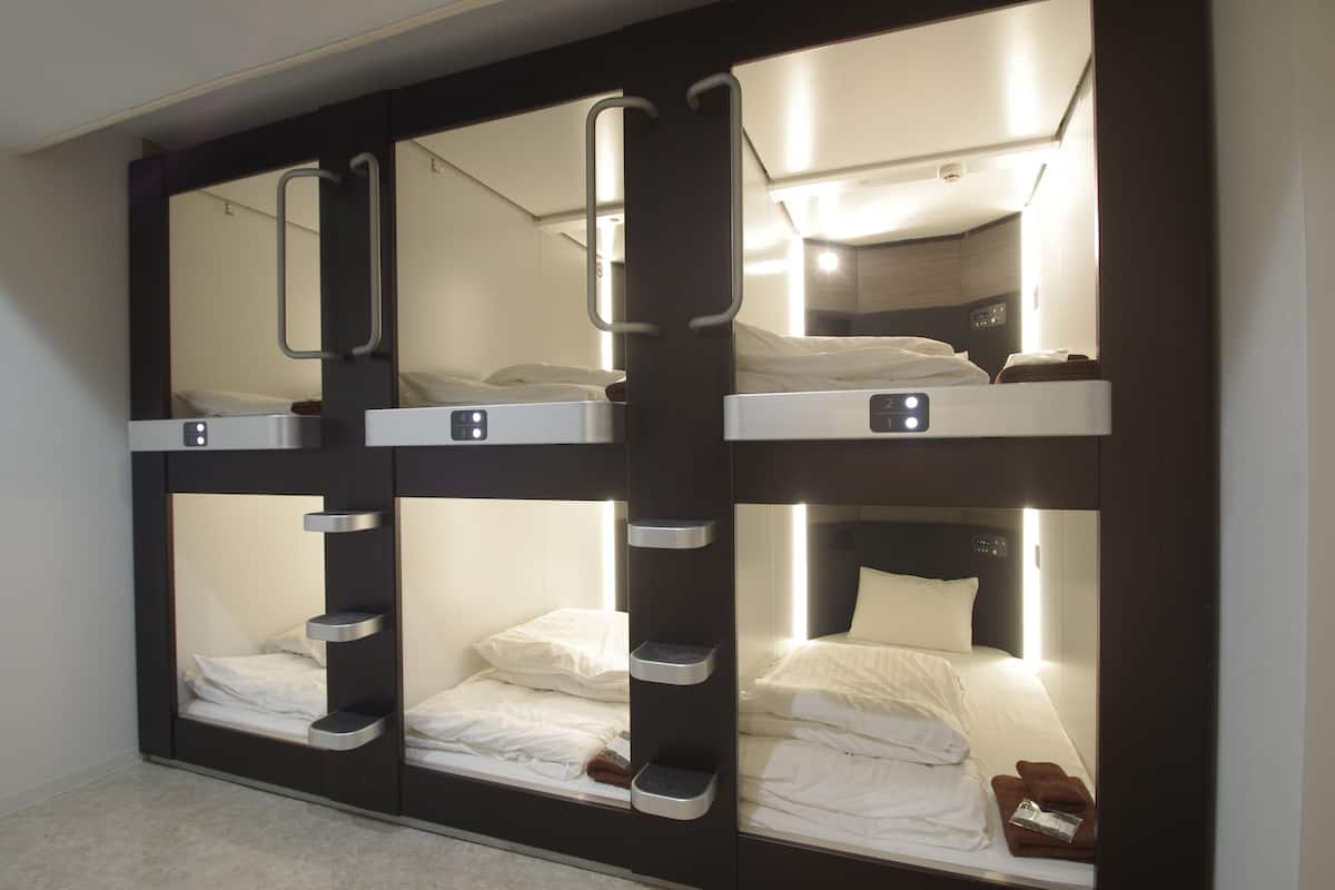 Camera con letto a castello, uno specchio, comodini e testiera.