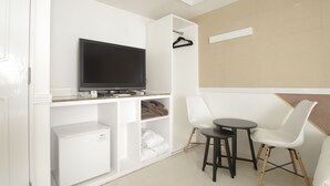 A modern room with a flat-screen TV, a white wardrobe, a small table, and two white chairs. - Hotel Imalle Yokohama Isezakicho - Hostel (Yokohama)