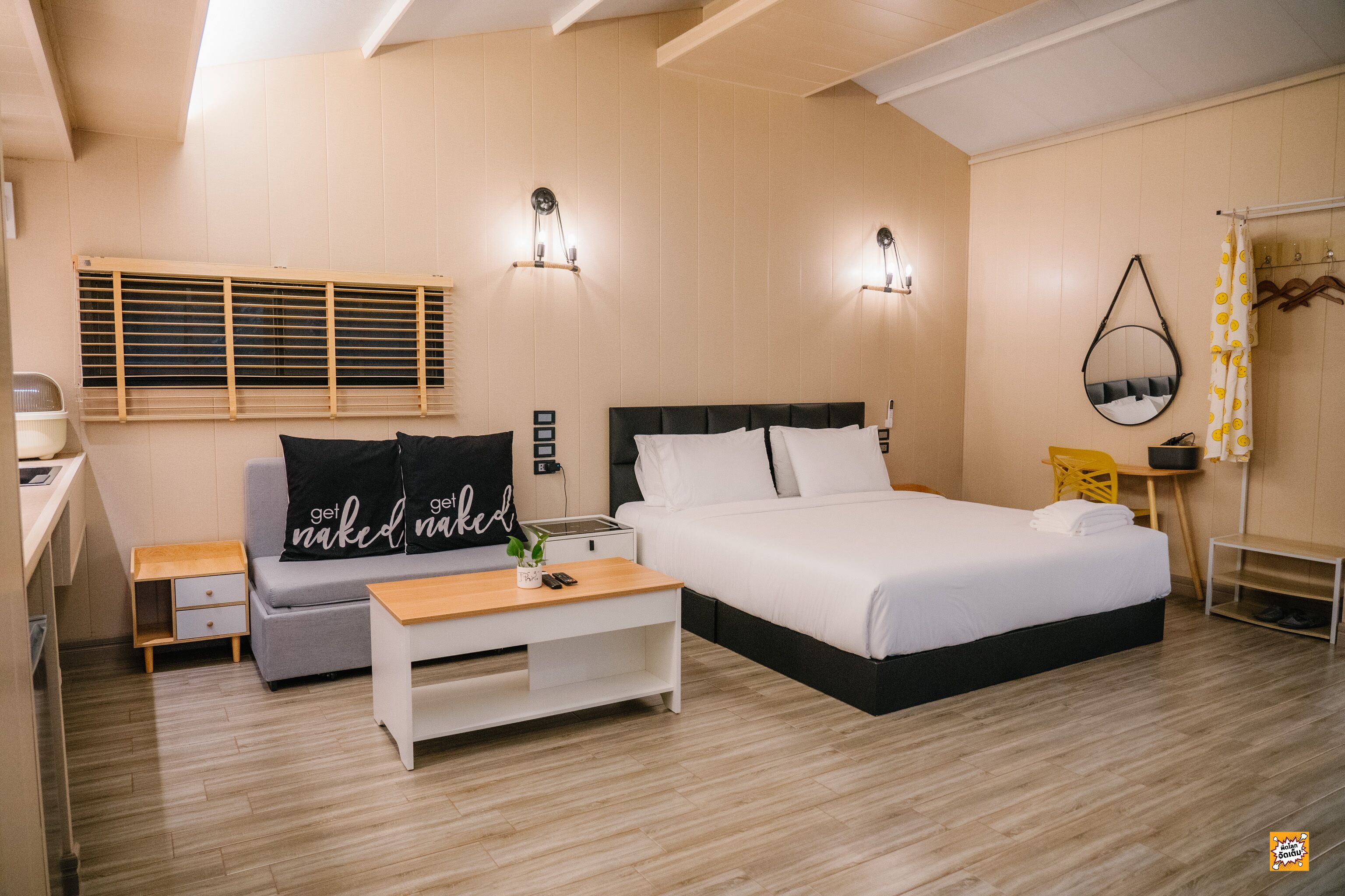 Un dormitorio moderno con cama, sofá, una mesita y un escritorio.