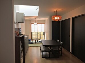 Una cocina compacta con zona de comedor, un ventanal grande y una lámpara de techo.