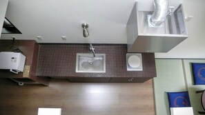 Un baño moderno con un lavamanos rectangular, un espejo integrado y un sistema de ventilación.