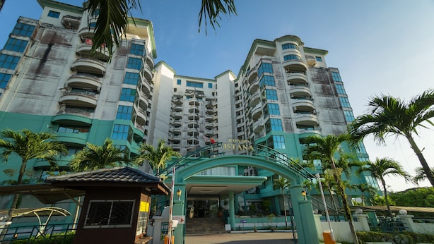 A multi-story hotel with a prominent entrance, palm trees, and a clear sky. -  Istana Residences Langkawi (Langkawi)