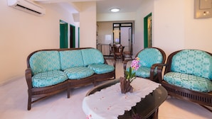 A living room with two sofas, a coffee table, and a dining table with chairs. -  Istana Residences Langkawi (Langkawi)