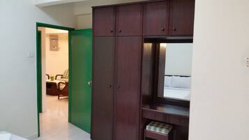 Una habitación con cama, una puerta verde y un armario.