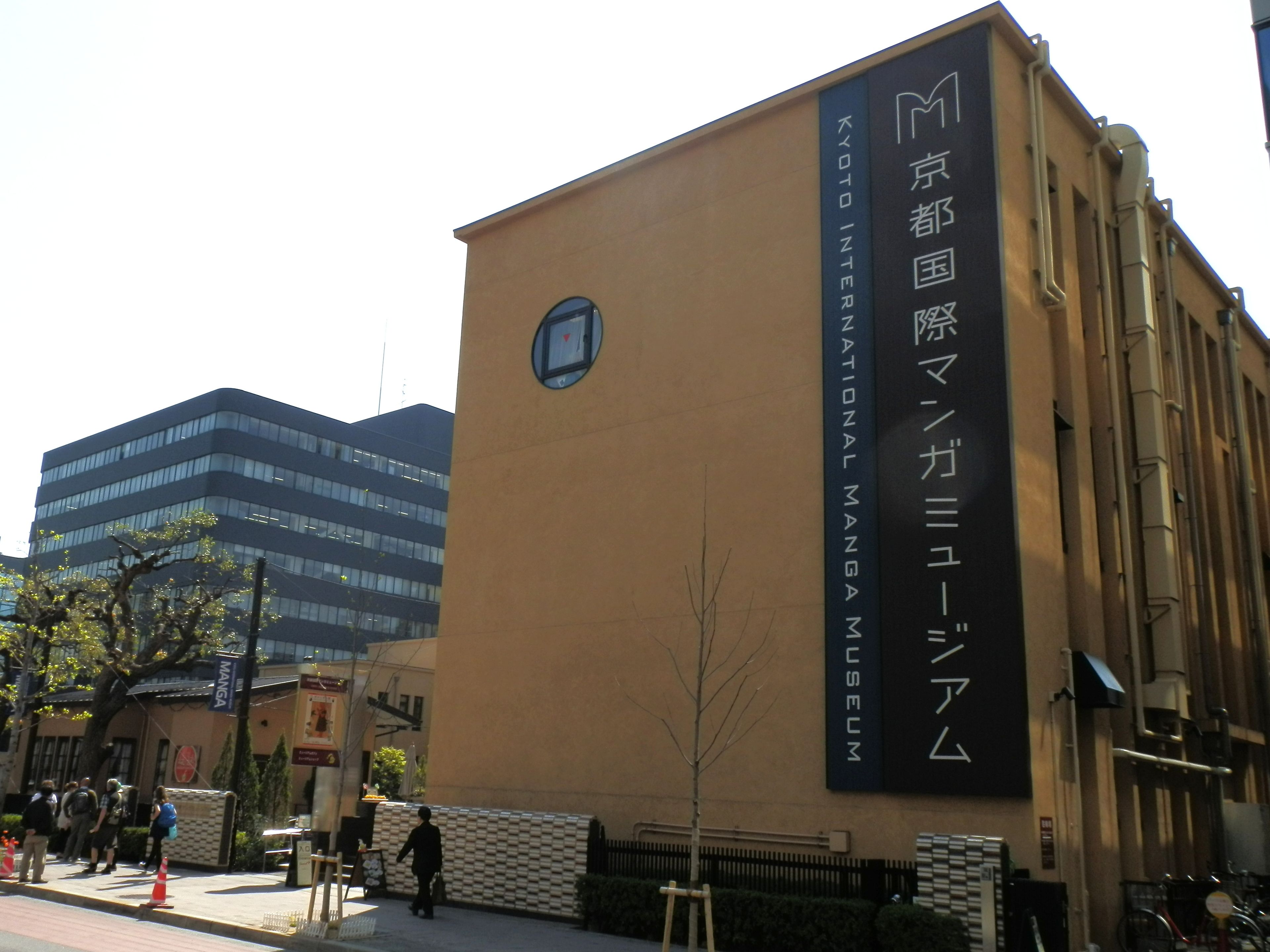Un edificio con un gran cartel que dice "Kyoto International Manga Museum".