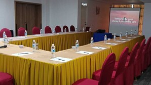 A conference room with a long table, chairs, water bottles, and a presentation screen. - Lipis Plaza Hotel (Kuala Lipis)