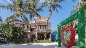 A beachfront property with a two-story building, a covered outdoor seating area, and a decorative archway. - Kinan Retreat (Fulidhoo)