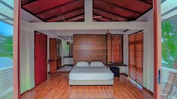 Ein modernes Schlafzimmer mit einem großen Bett, Holzboden und einer schrägen Decke.