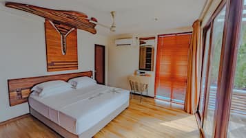 Un dormitorio con cama, escritorio y ventana con persianas.
