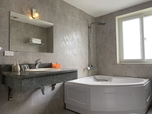 A modern bathroom with a freestanding bathtub, a large mirror, and a window. - Chio Hotel and Apartment (Hanoi)