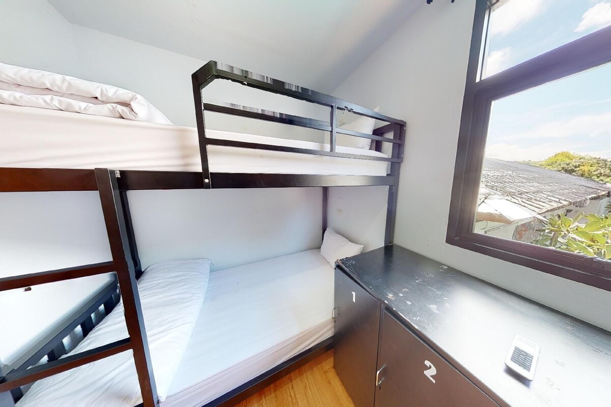 A bunk bed room with a window providing a view of the outside.