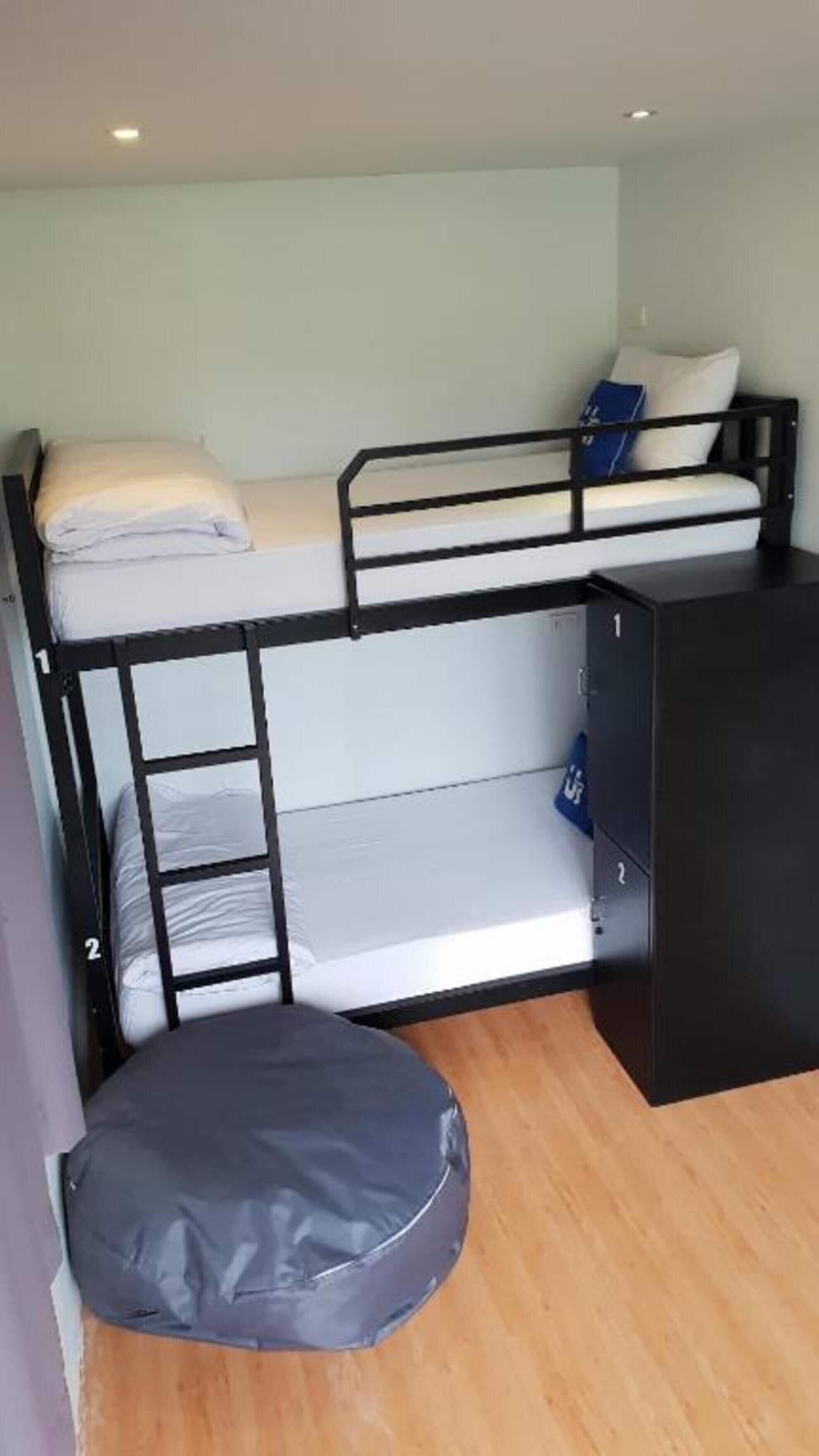 A bunk bed with a lower bunk, a small desk, and a storage cabinet.