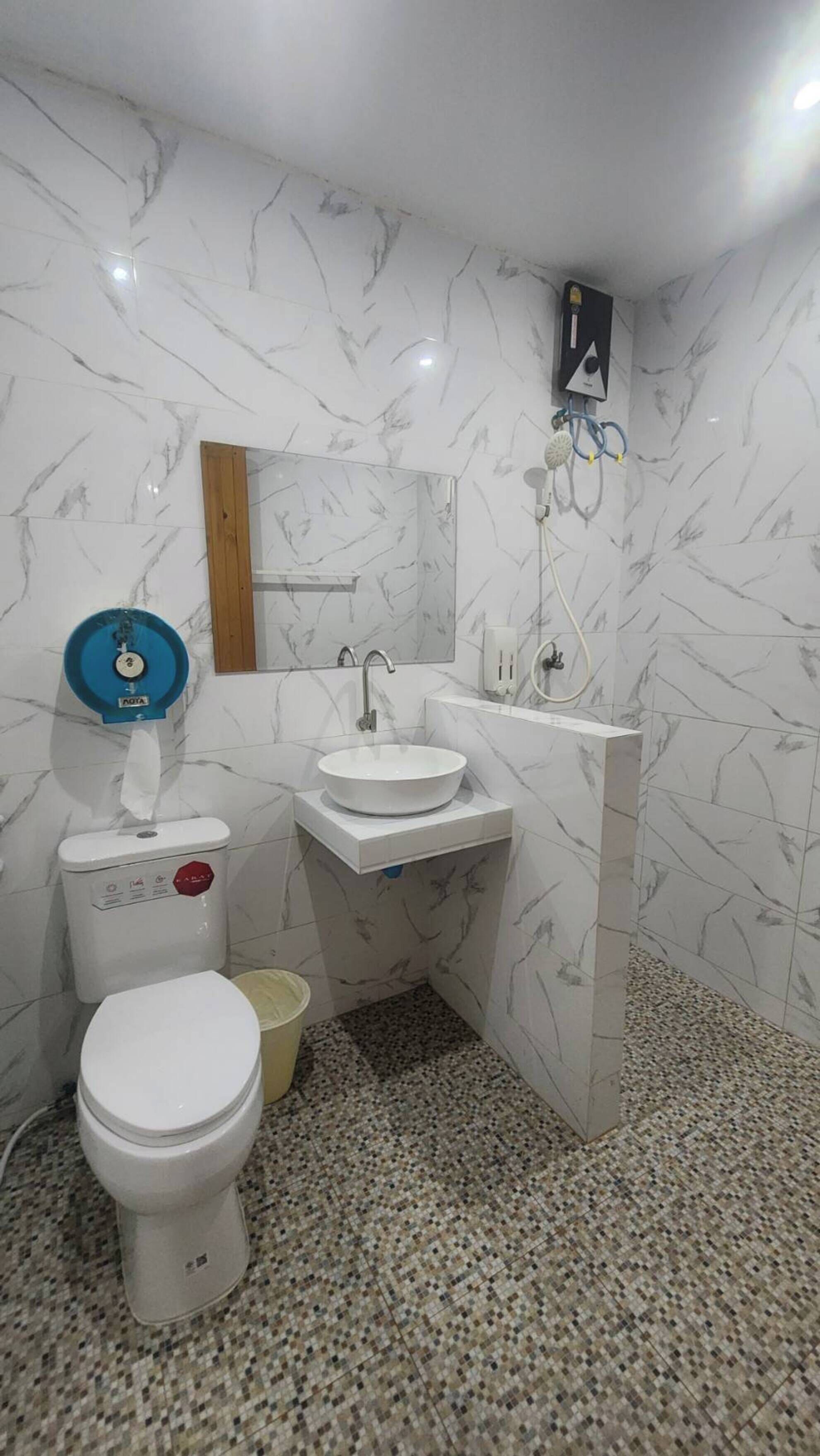 A bathroom with a toilet, sink, and mirror.