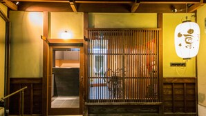 A traditional Japanese entrance with a sliding door, a bicycle, and a hanging lantern. - Rin Kyoto (Kyoto)