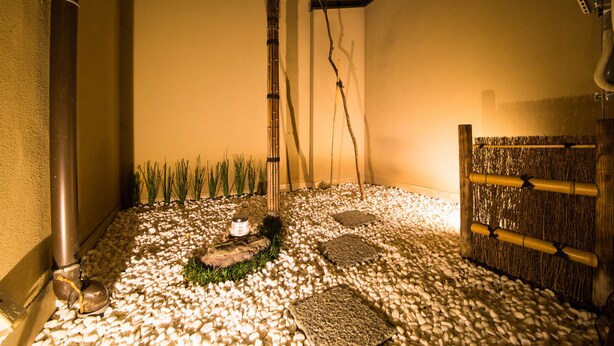 A serene indoor garden with a gravel path, bamboo, and a wooden fence. - Rin Kyoto (Kyoto)