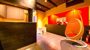 A reception area with a wicker chair, a small stool, and a fire extinguisher. - Rin Kyoto (Kyoto)