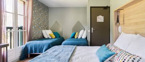 A hotel room with two beds, a wooden headboard, a patterned wall, and a door with a sign.
