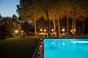 Una piscina al aire libre de temporada, sombrillas