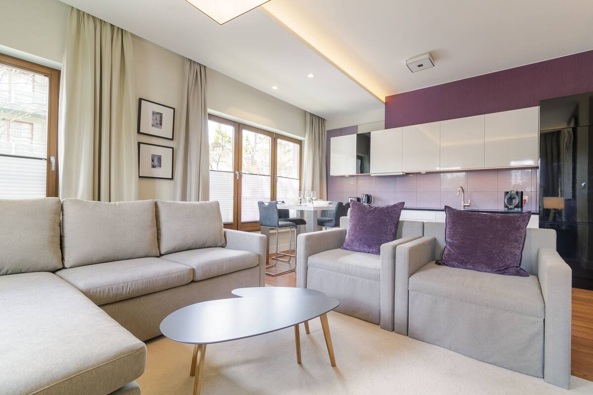 Una sala de estar moderna con un sofá, sillones y una mesa de centro.