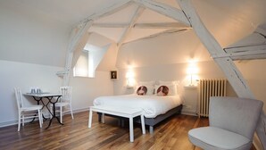 A bedroom with a bed, bedside tables, a chair, and a table.