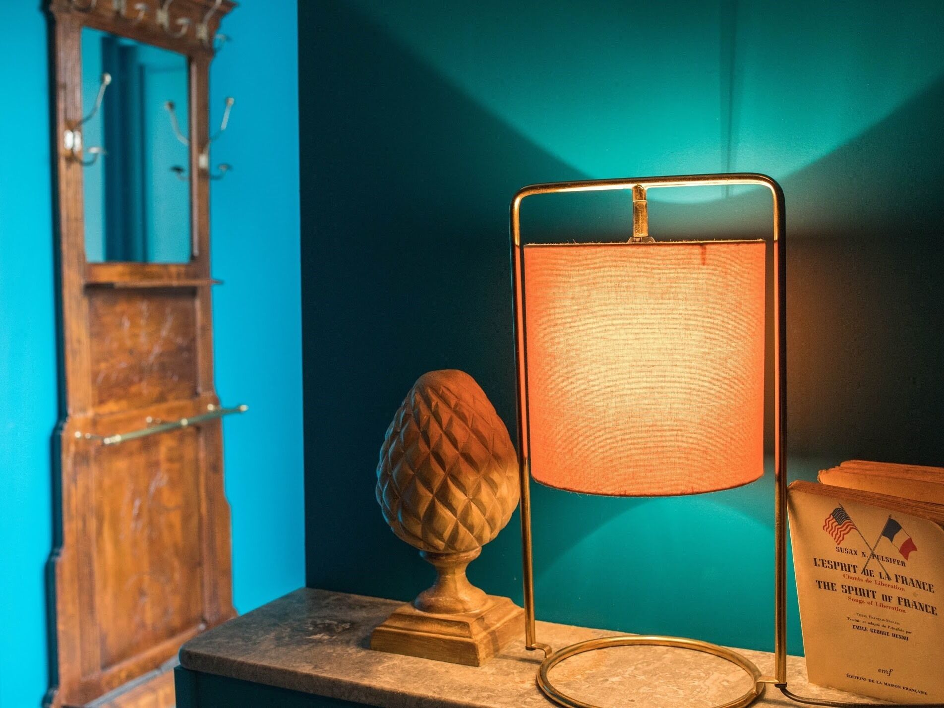 A table with a lamp, a decorative object, and a book titled 'Lesprit de la France'.