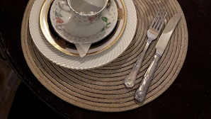 A dining table set with plates, cutlery, and a candle. - Lee's House Bed & Breakfast Sliema (Sliema)