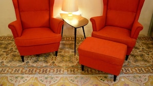 Two orange armchairs and a matching ottoman in a room with patterned floor tiles. - Lee's House Bed & Breakfast Sliema (Sliema)