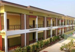 Un hotel de varios pisos con balcones, un paseo cubierto y un jardín ajardinado.