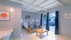 A modern room with a bed, a sofa, a desk, and a table. - Reef Beach Resort (General Luna)