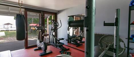 A gym with exercise equipment, a punching bag, and a weightlifting area.