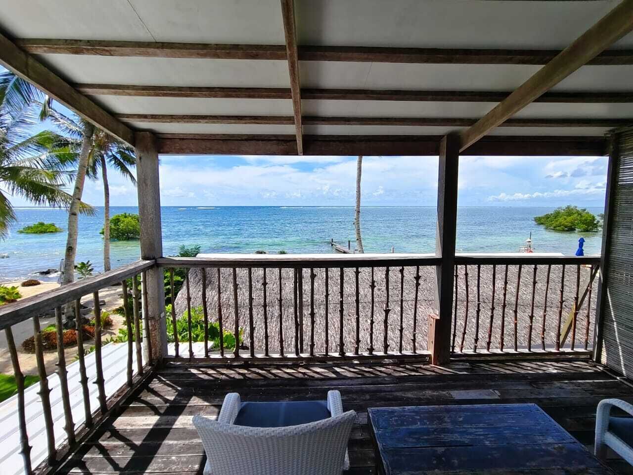 Ein überdachter Außenbereich mit Blick auf den Strand und den Ozean.