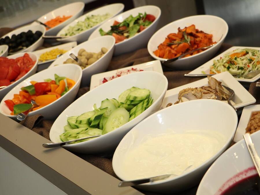 A buffet with various dishes including salads, vegetables, and meats.