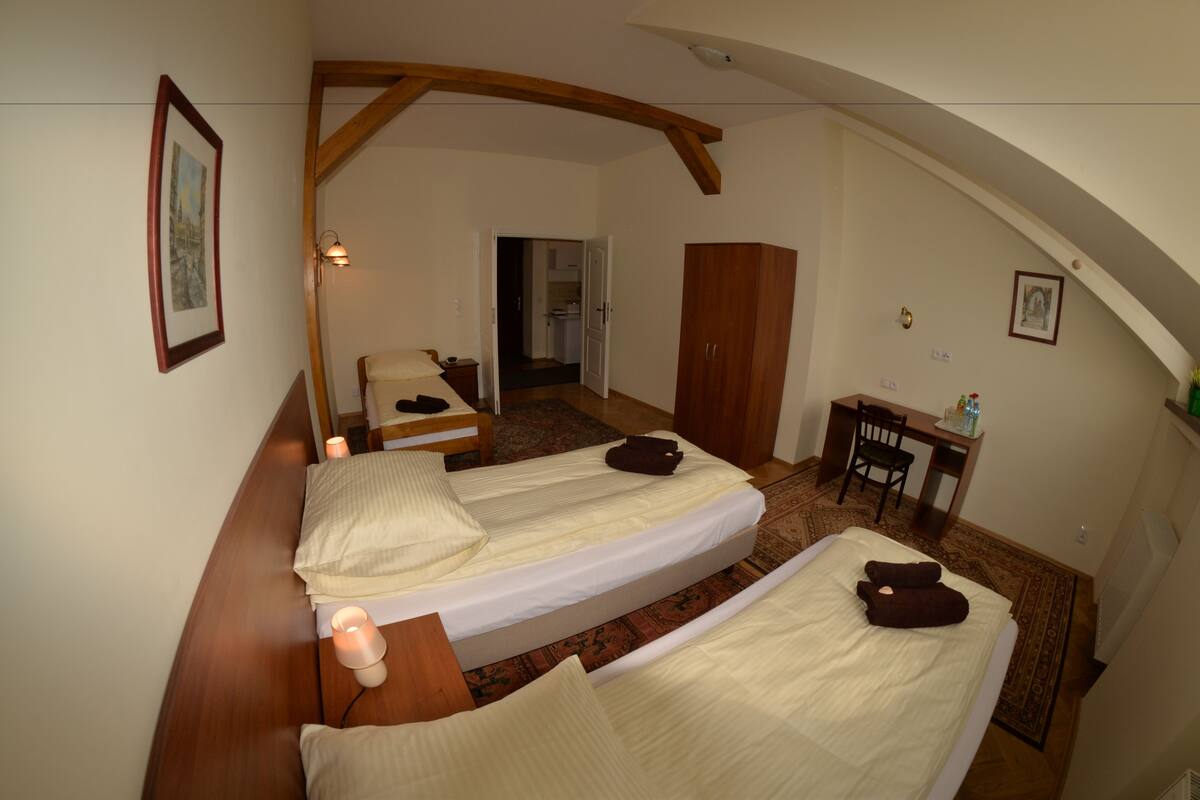A room with two beds, a desk, and a chair.