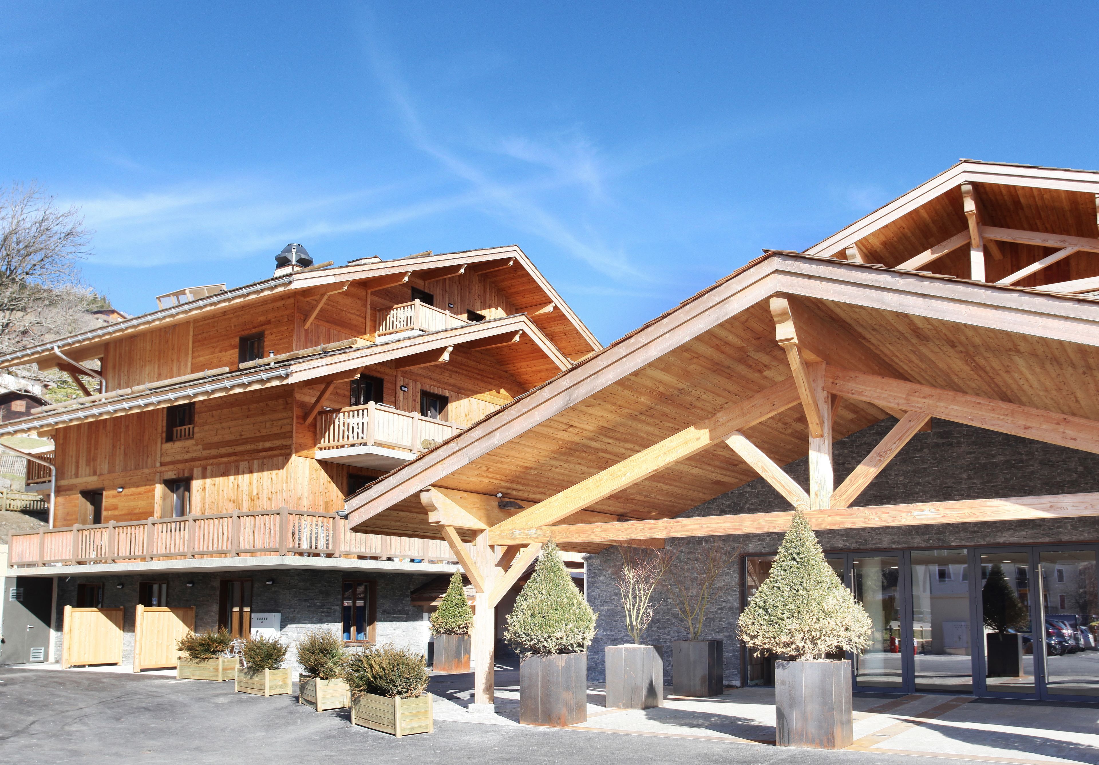 Un bâtiment en bois doté de plusieurs balcons et d’un espace d’entrée abrité.