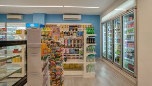 A grocery store interior with shelves stocked with various products, a refrigerated section, and a display of colorful items. - GM Hotel Sunway Metro (Petaling Jaya)