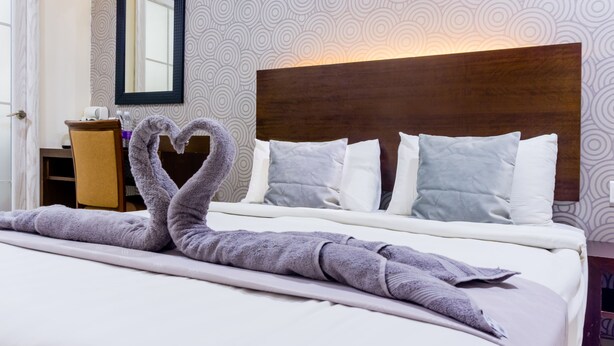 A hotel room with a neatly made bed, a wooden headboard, and a mirror on the wall. - GM Hotel Sunway Metro (Petaling Jaya)